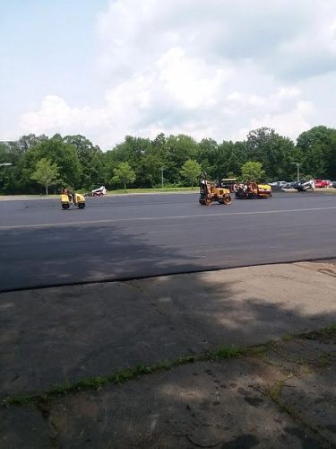 A spacious parking lot filled with various tractors and trucks parked in organized rows.